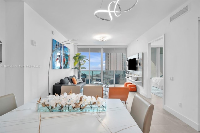 17550 Collins Ave Unit 704, Sunny Isles Beach, FL 33160 - tiled dining area with a chandelier, floor to ceiling windows, and baseboards