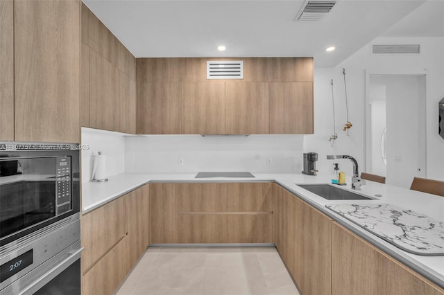 17550 Collins Ave Unit 704, Sunny Isles Beach, FL 33160 - kitchen featuring a sink, modern cabinets, built in microwave, oven, and light countertops
