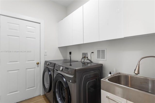 4017 W Gardenia Ave, Weston, FL 33332 - laundry area featuring cabinet space, washer and clothes dryer, and light wood finished floors