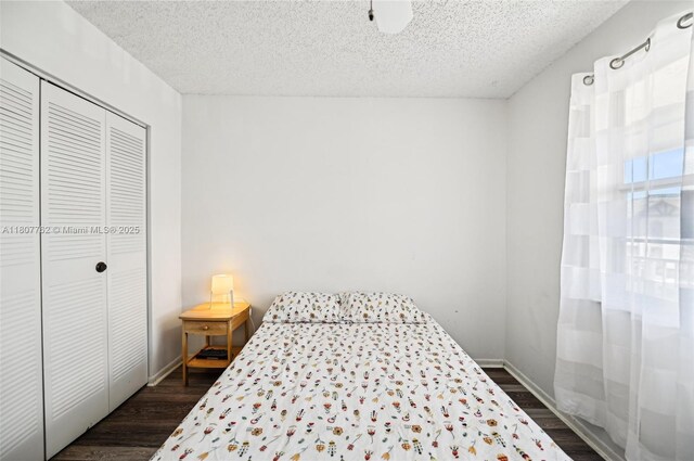 2391 NW 89th Dr Unit 409, Coral Springs, FL 33065 - bedroom with dark wood finished floors, a closet, a textured ceiling, and baseboards