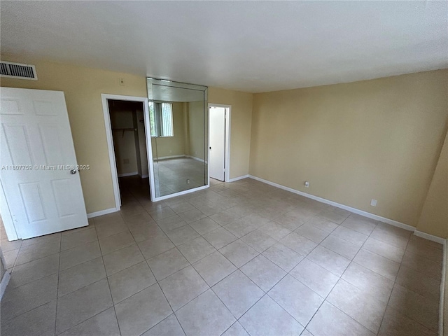 4222 Inverrary Blvd Unit 4211, Lauderhill, FL 33319 - unfurnished bedroom featuring light tile patterned floors, a spacious closet, baseboards, and a closet