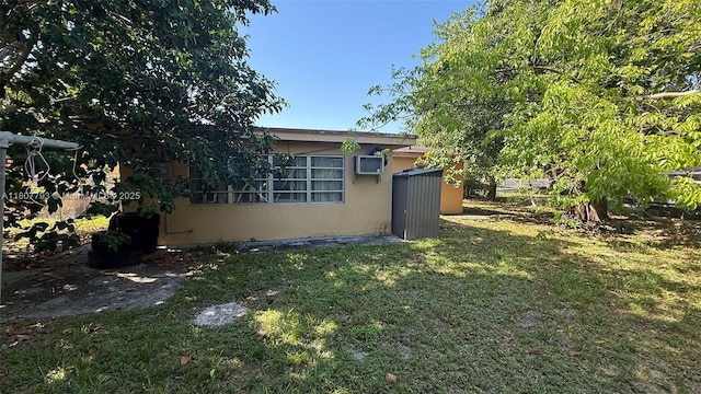 1230 NW 113th Ter, Miami, FL 33167 - view of side of property featuring a lawn, stucco siding, and a wall unit AC