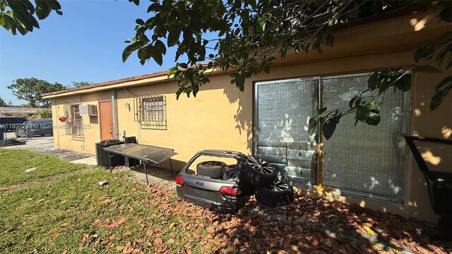 1230 NW 113th Ter, Miami, FL 33167 - view of side of property featuring stucco siding and a wall mounted air conditioner