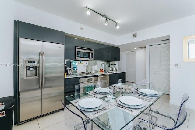 31 SE 6th St Unit 2408, Miami, FL 33131 - kitchen with appliances with stainless steel finishes, dark cabinetry, light countertops, light tile patterned flooring, and a sink