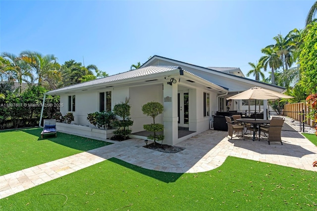 1550 Tyler St, Hollywood, FL 33020 - back of property featuring a patio area, stucco siding, and metal roof