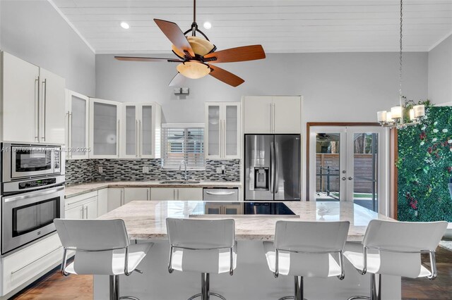 1550 Tyler St, Hollywood, FL 33020 - kitchen featuring appliances with stainless steel finishes, a sink, french doors, tasteful backsplash, and white cabinets