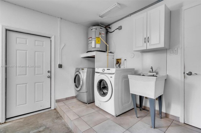 1550 Tyler St, Hollywood, FL 33020 - washroom featuring electric water heater, washing machine and clothes dryer, cabinet space, baseboards, and light tile patterned floors