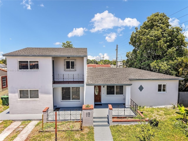 15 W 55th St, Hialeah, FL 33012 - view of front of house with a porch, stucco siding, a shingled roof, and a balcony