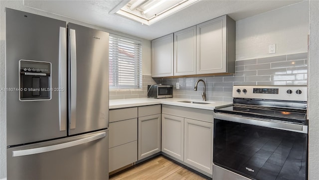 15 W 55th St, Hialeah, FL 33012 - kitchen featuring stainless steel appliances, a sink, gray cabinets, and light countertops