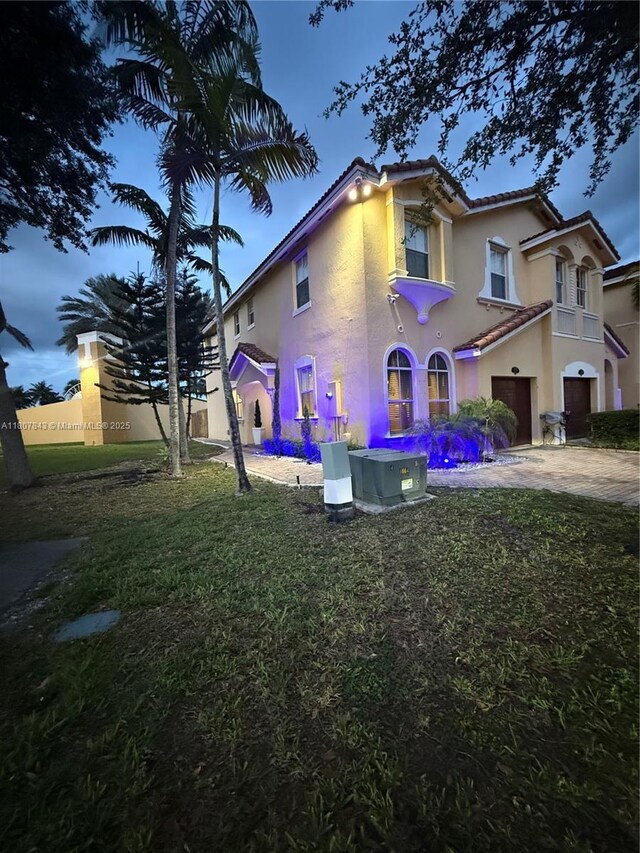 15029 SW 8th Ter, Miami, FL 33194 - rear view of house with a tile roof, stucco siding, a lawn, and a garage