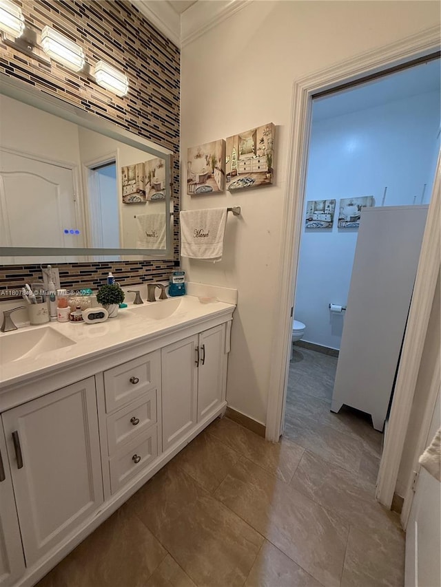 15029 SW 8th Ter, Miami, FL 33194 - full bathroom with toilet, double vanity, decorative backsplash, crown molding, and baseboards