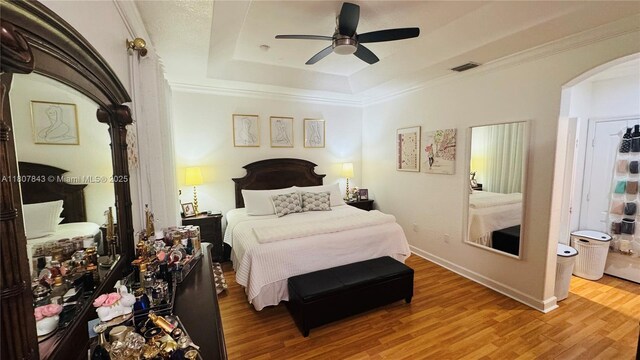 15029 SW 8th Ter, Miami, FL 33194 - bedroom with arched walkways, a tray ceiling, wood finished floors, ornamental molding, and baseboards