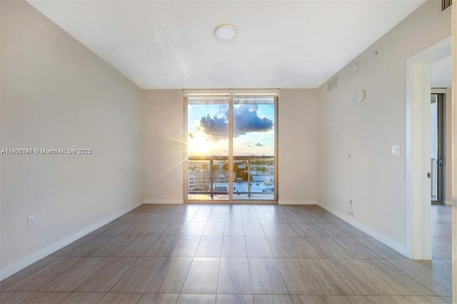 3900 Biscayne Blvd Unit N-905, Miami, FL 33137 - spare room featuring baseboards, tile patterned floors, and floor to ceiling windows