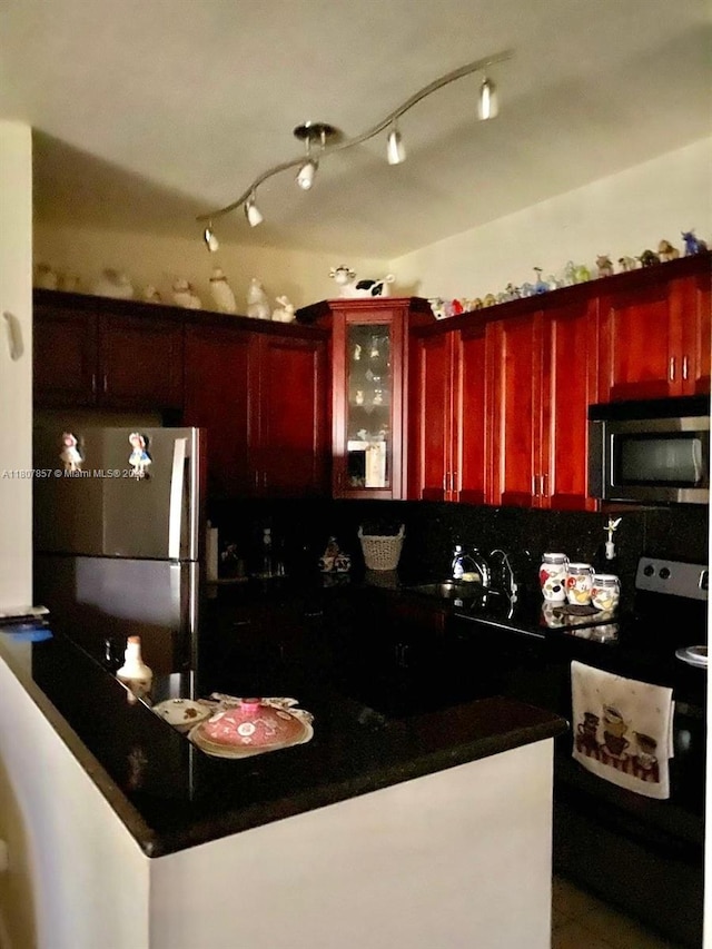 7707 Ashmont Cir Unit 214, Tamarac, FL 33321 - kitchen with dark brown cabinets, appliances with stainless steel finishes, dark countertops, a sink, and backsplash