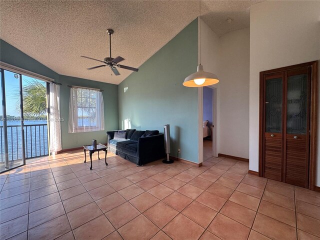 15569 N Miami Lakeway N Unit 204, Miami Lakes, FL 33014 - living room with a textured ceiling, ceiling fan, light tile patterned flooring, high vaulted ceiling, and baseboards