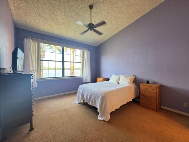 15569 N Miami Lakeway N Unit 204, Miami Lakes, FL 33014 - carpeted bedroom featuring a textured ceiling, vaulted ceiling, a ceiling fan, and baseboards
