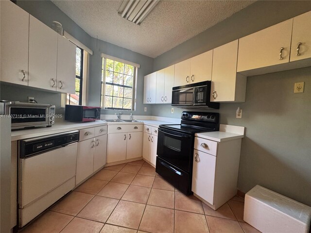 15569 N Miami Lakeway N Unit 204, Miami Lakes, FL 33014 - kitchen featuring black appliances, a textured ceiling, light countertops, a sink, and light tile patterned flooring