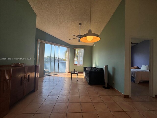 15569 N Miami Lakeway N Unit 204, Miami Lakes, FL 33014 - living area featuring lofted ceiling, a textured ceiling, a ceiling fan, and light tile patterned flooring
