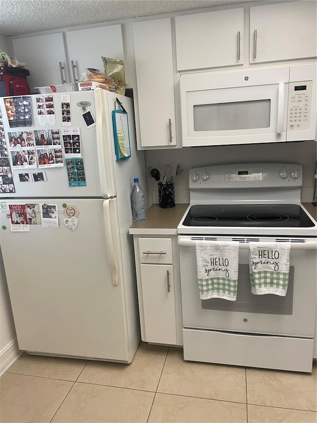 5200 NW 31st Ave Unit 102, Fort Lauderdale, FL 33309 - kitchen with white appliances, white cabinets, light tile patterned flooring, and light countertops