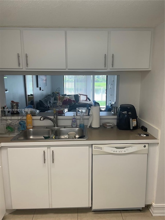 5200 NW 31st Ave Unit 102, Fort Lauderdale, FL 33309 - kitchen featuring white dishwasher, white cabinetry, a sink, light countertops, and light tile patterned floors