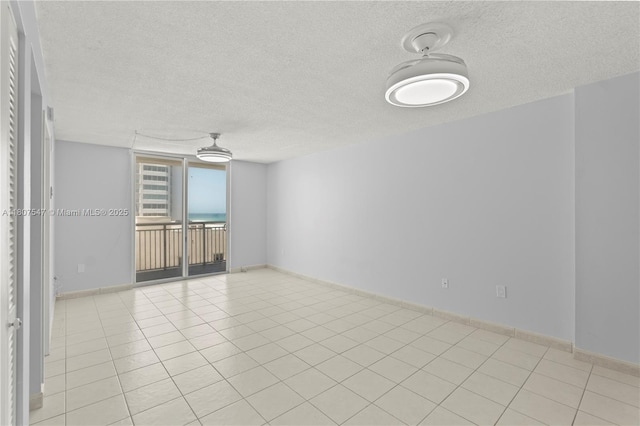 6969 Collins Ave Unit 707, Miami Beach, FL 33141 - spare room with a textured ceiling, light tile patterned floors, and baseboards