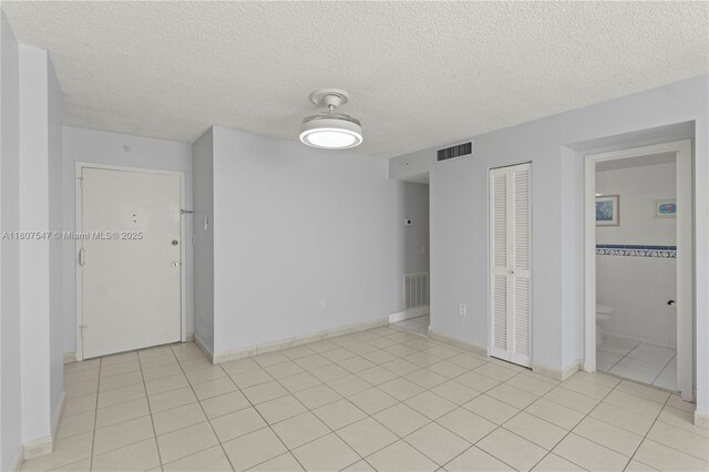 6969 Collins Ave Unit 707, Miami Beach, FL 33141 - spare room with a textured ceiling, light tile patterned floors, and baseboards