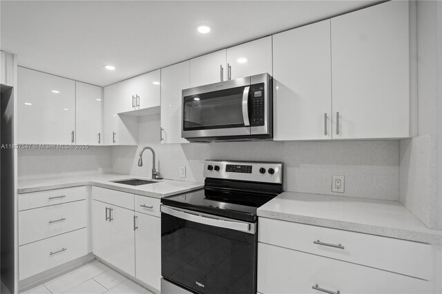 6969 Collins Ave Unit 707, Miami Beach, FL 33141 - kitchen with stainless steel appliances, a sink, white cabinetry, light countertops, and recessed lighting