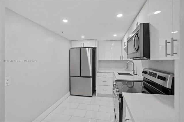 6969 Collins Ave Unit 707, Miami Beach, FL 33141 - kitchen with stainless steel appliances, a sink, white cabinets, modern cabinets, and recessed lighting