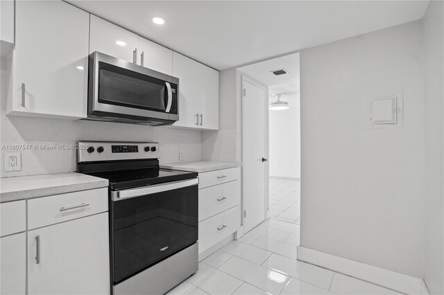 6969 Collins Ave Unit 707, Miami Beach, FL 33141 - kitchen with stainless steel appliances, light countertops, white cabinets, and recessed lighting