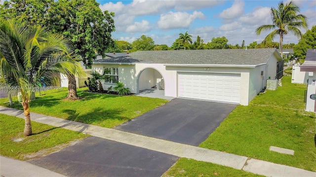 2001 NW 93rd Ln, Sunrise, FL 33322 - view of front of house with asphalt driveway, an attached garage, a front lawn, and stucco siding
