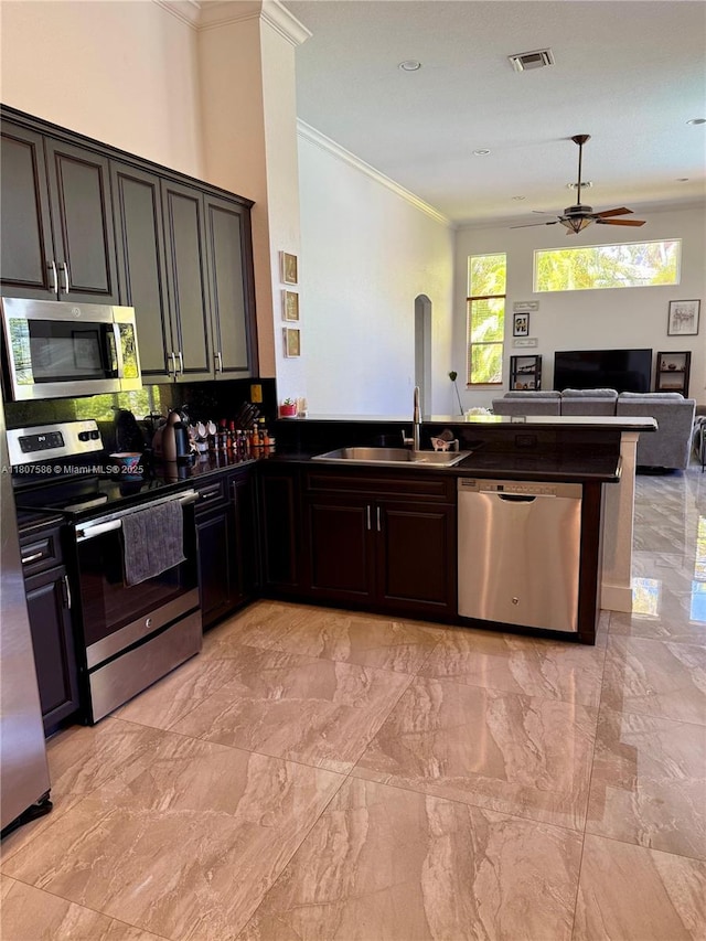 3700 Oak Ridge Ln, Weston, FL 33331 - kitchen featuring appliances with stainless steel finishes, a sink, a ceiling fan, ornamental molding, and a peninsula