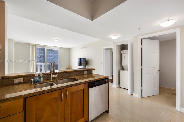 1755 E Hallandale Beach Blvd Unit 1604E, Hallandale Beach, FL 33009 - kitchen featuring stainless steel dishwasher, a sink, stacked washing machine and dryer, brown cabinets, and dark stone counters
