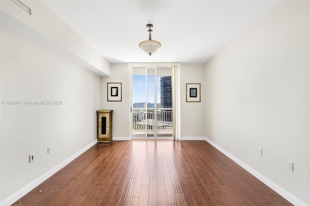 1755 E Hallandale Beach Blvd Unit 1604E, Hallandale Beach, FL 33009 - spare room with expansive windows, dark wood-style flooring, and baseboards
