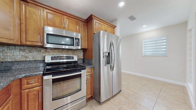 5301 SW 111th Ave, Miami, FL 33165 - kitchen with stainless steel appliances, backsplash, brown cabinetry, light tile patterned floors, and baseboards
