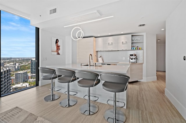 650 NE 32nd St Unit 4101, Miami, FL 33137 - kitchen with a sink, floor to ceiling windows, modern cabinets, a kitchen bar, and open shelves