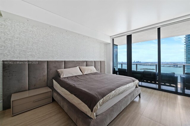 650 NE 32nd St Unit 4101, Miami, FL 33137 - bedroom with floor to ceiling windows, wood finished floors, access to outside, and a water view