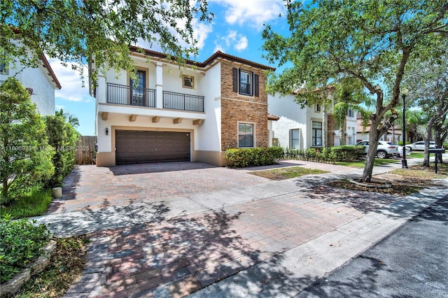 557 SE 37th Pl, Homestead, FL 33033 - view of front of property featuring a balcony, stucco siding, an attached garage, decorative driveway, and stone siding