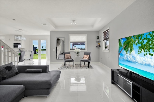557 SE 37th Pl, Homestead, FL 33033 - living room featuring a raised ceiling, light tile patterned flooring, and baseboards