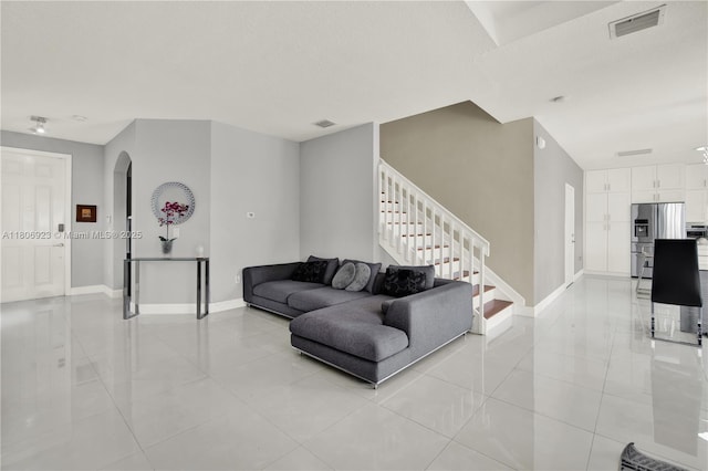 557 SE 37th Pl, Homestead, FL 33033 - living area with light tile patterned flooring, arched walkways, baseboards, and stairway