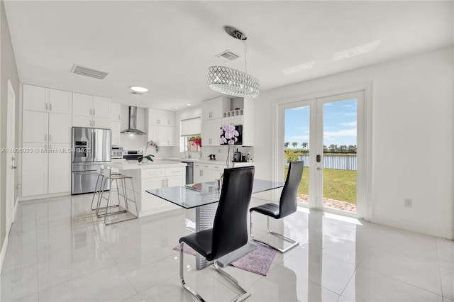 557 SE 37th Pl, Homestead, FL 33033 - dining room featuring french doors, a water view, light tile patterned flooring, baseboards, and a chandelier