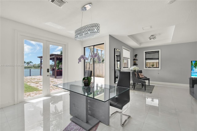 557 SE 37th Pl, Homestead, FL 33033 - dining area with light tile patterned floors, baseboards, a chandelier, and french doors