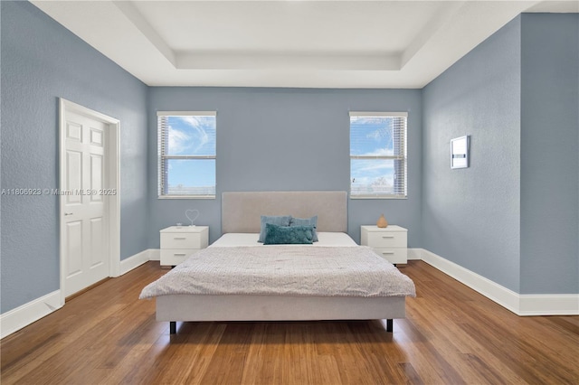 557 SE 37th Pl, Homestead, FL 33033 - bedroom with a raised ceiling, dark wood-style floors, a textured wall, and baseboards