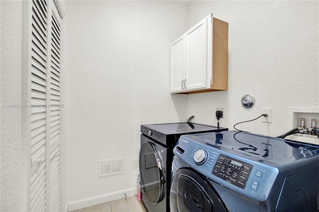 557 SE 37th Pl, Homestead, FL 33033 - laundry area featuring cabinet space, washing machine and clothes dryer, light tile patterned floors, and baseboards