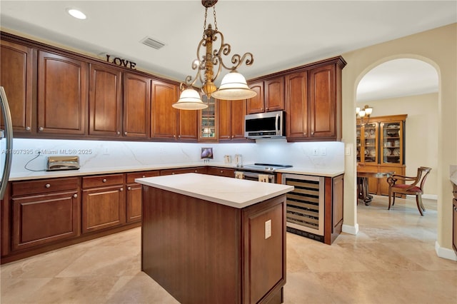 7582 SW 191st St, Cutler Bay, FL 33157 - kitchen featuring stainless steel appliances, arched walkways, light countertops, backsplash, and wine cooler