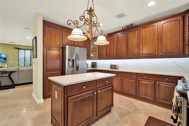 7582 SW 191st St, Cutler Bay, FL 33157 - kitchen with stainless steel appliances, decorative light fixtures, light countertops, a center island, and glass insert cabinets