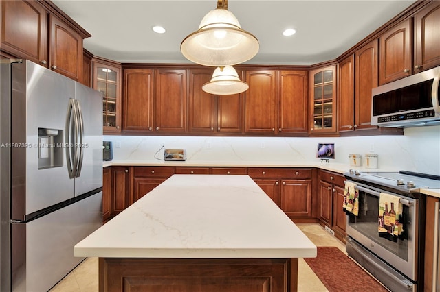 7582 SW 191st St, Cutler Bay, FL 33157 - kitchen with appliances with stainless steel finishes, light countertops, a kitchen island, hanging light fixtures, and glass insert cabinets