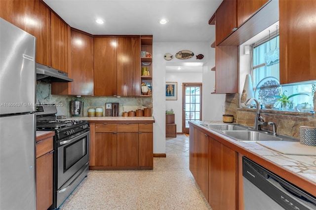 1895 SW 25th St, Miami, FL 33133 - kitchen with appliances with stainless steel finishes, under cabinet range hood, a sink, brown cabinetry, and tile countertops
