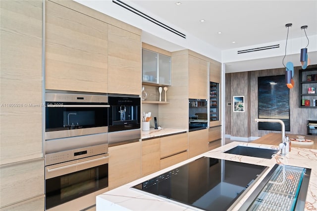 2200 N Ocean Blvd Unit N1102, Fort Lauderdale, FL 33305 - kitchen featuring a sink, modern cabinets, light stone countertops, black electric stovetop, and light brown cabinets