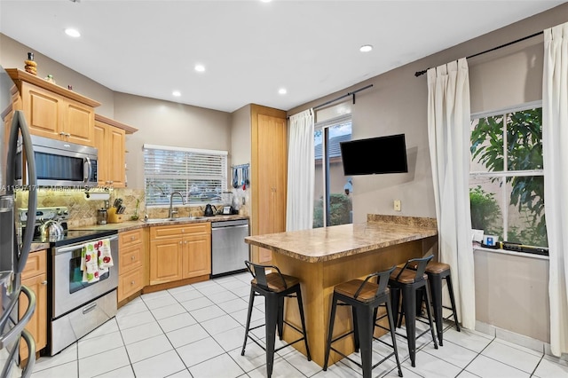 349 NW 207th Ave, Pembroke Pines, FL 33029 - kitchen featuring appliances with stainless steel finishes, a sink, light brown cabinets, a kitchen breakfast bar, and recessed lighting