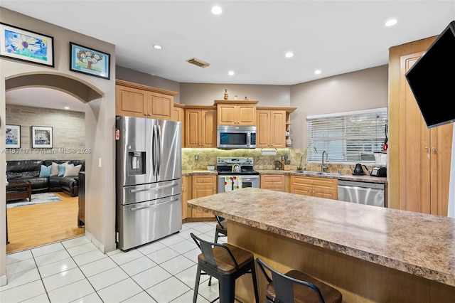 349 NW 207th Ave, Pembroke Pines, FL 33029 - kitchen with appliances with stainless steel finishes, a sink, a kitchen bar, backsplash, and light tile patterned floors